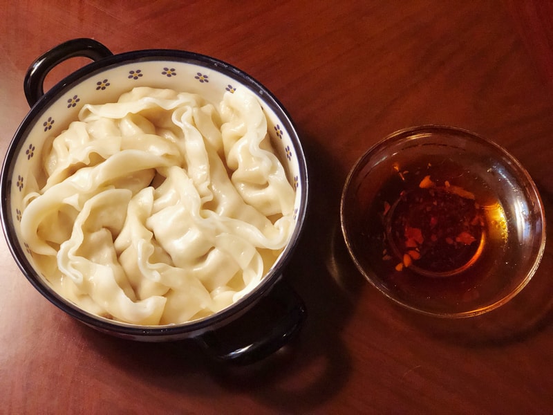 渡深咖啡廳的豬肉高麗菜水餃，搭配提味辣油，展現簡單家常料理的溫暖與療癒風味。