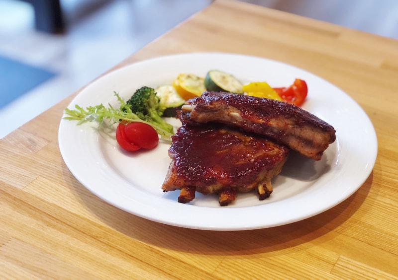 BBQ經典烤豬肋排 以蜂蜜烹調濃郁香甜的醬汁、獨特的誘人香氣。搭配爽脆櫛瓜與多汁蔬果，肉質紮實、甜鹹交錯。讓人食指大動允指回味，是道滿滿的飽足感餐點。