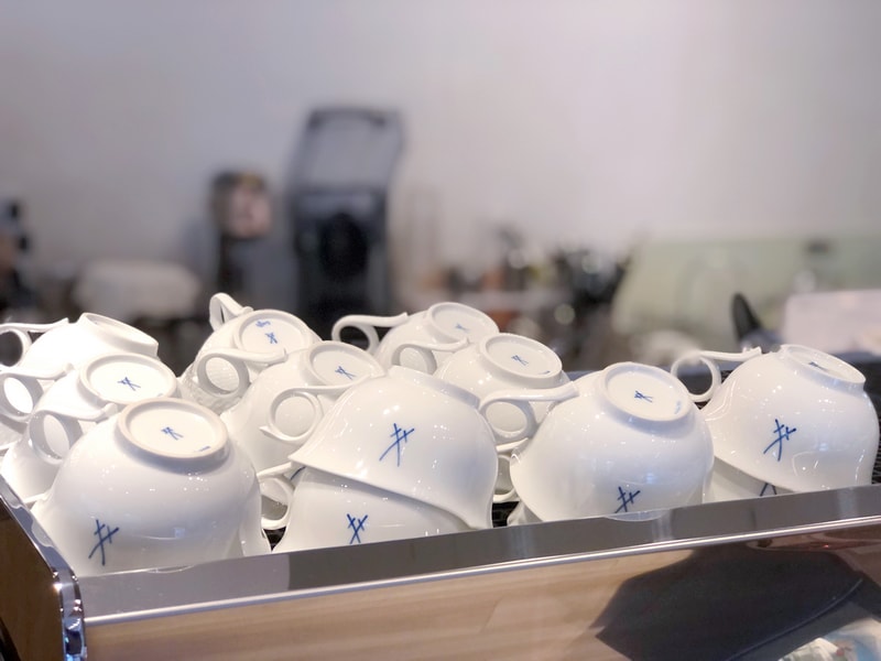 一排倒置的白瓷咖啡杯，藍色標誌低調卻充滿質感的MEISSEN麥森瓷器。